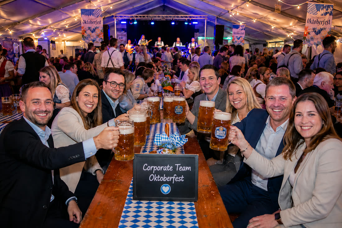 Corporate team raising beers together at Oktoberfest